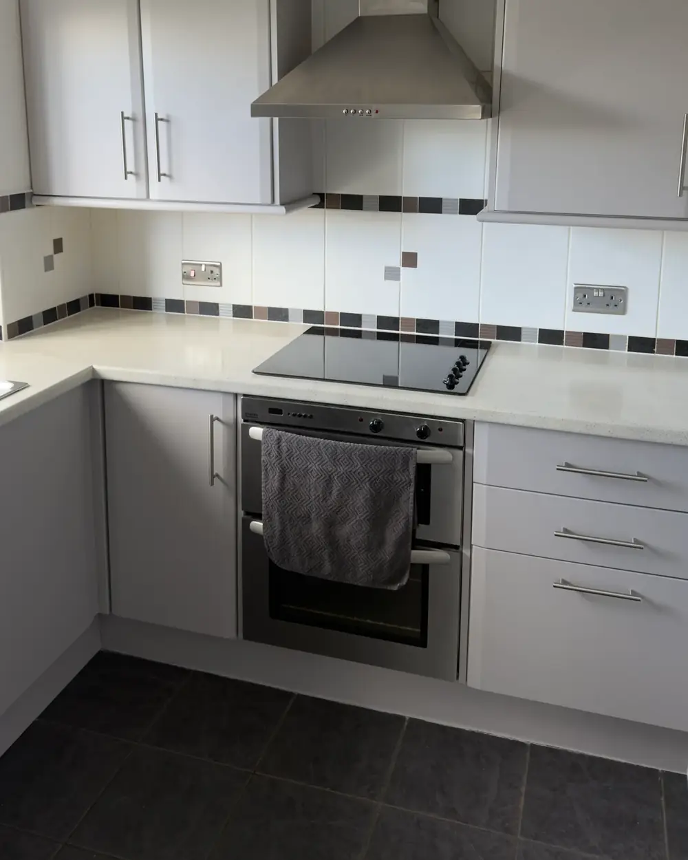 After: Kitchen cabinets sprayed in Perfectly Taupe, worktops sprayed in Fossil Stone effect